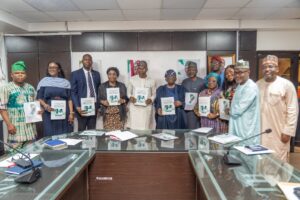 Dr. Iziaq Adekunle Salako holding the Report Booklet with Prof. Isaac Adewole Chairman Taskforce on Elimination of Cervical Cancer Committee. 2nd Left: Dr. Abisola Adegoke mni, representing Dr. Salahudeen Jimoh mni, Director Hospital Services Department in the Ministry; 1st left: Dr. Uchechukwu Nwokwu Coordinator National Cervical Cancer Programme in the Ministry; extreme right: Ptof. Usman Aliyu, Director General National Institute for Cancer Research and Treatment NICRAT.